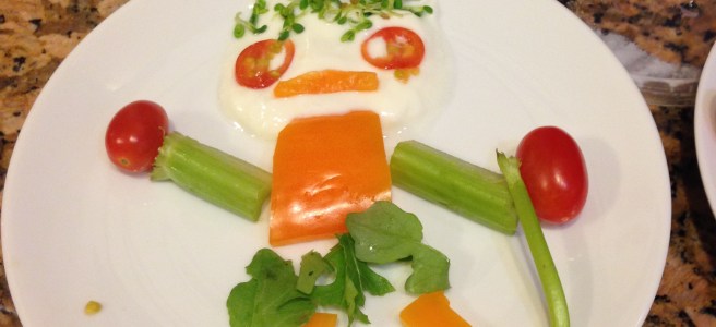 salad person made of yogurt and vegetables with pepper moustache, arugula skirt, and celery stick cane