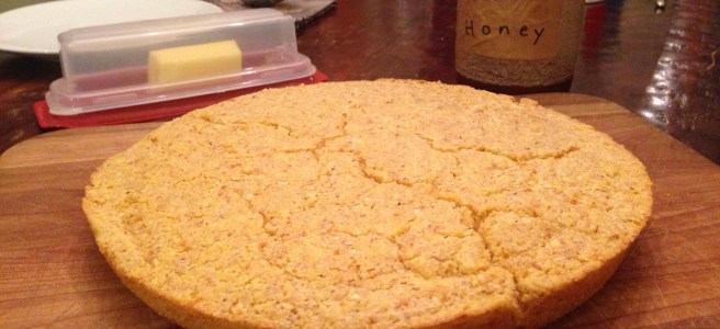 a round of cronbread with honey and butter in the background